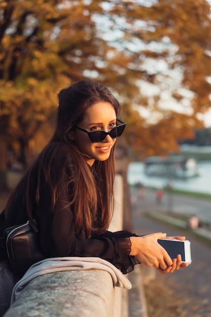 Aantrekkelijke vrouw die smartphone in openlucht in het park gebruiken