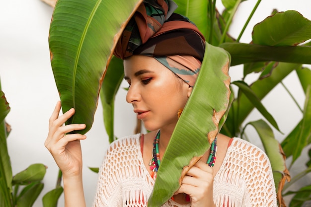 Aantrekkelijke vrouw draagt een kleurrijke hoofddoek als een tulband en grote ronde oorbellen