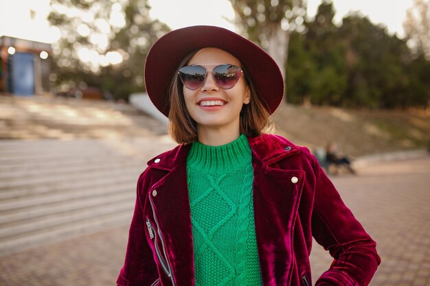 Aantrekkelijke vrouw in trendy outfit in herfststijl die op straat loopt