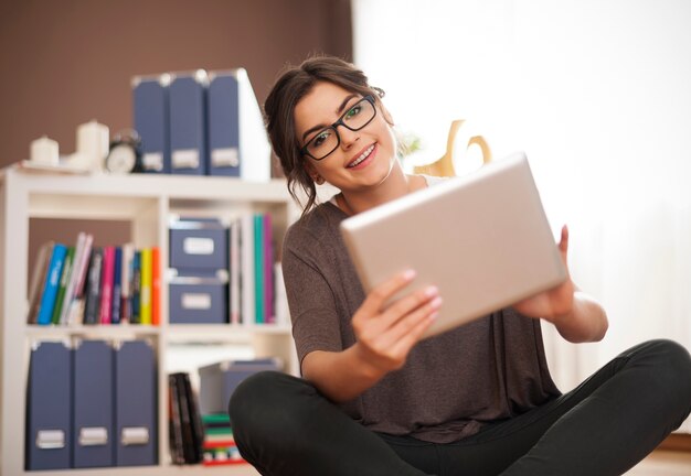 Aantrekkelijke vrouw met behulp van digitale tablet thuis