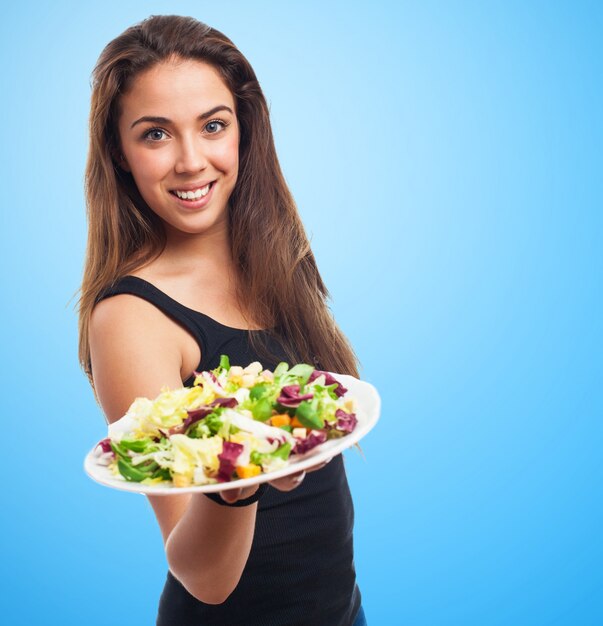 Aantrekkelijke vrouw met een plaat van salade