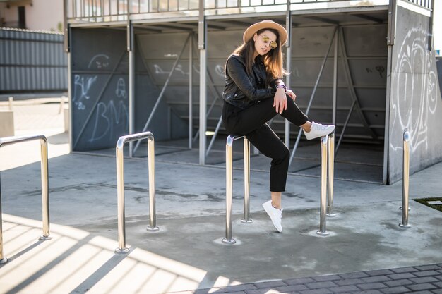 Aantrekkelijke vrouw met gouden haren poseren in het skatepark in het stadscentrum