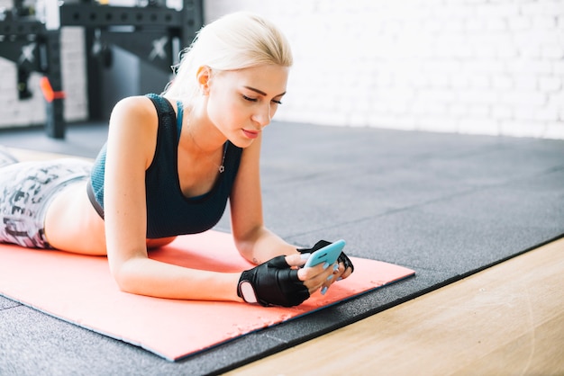 Aantrekkelijke vrouw rustend en met behulp van smartphone