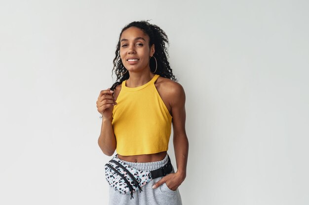 Aantrekkelijke zwarte Afro-Amerikaanse vrouw poseren in stijlvolle hipster outfit op witte achtergrond