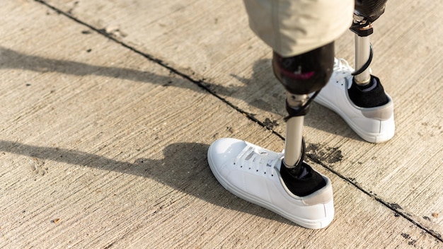 Gratis foto aanzicht van een man met prothetische benen en witte sneakers