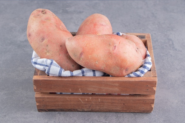 Aardappel op de handdoek in de doos op het marmeren oppervlak