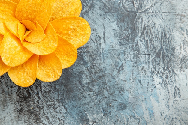 Aardappelchips versierd als bloem gevormd in een bruine kom op grijze tafel