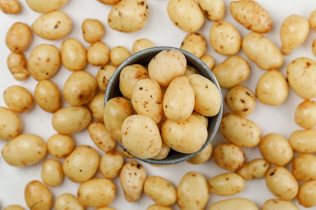 Aardappelen in een mini-emmer bovenaanzicht op een witte muur