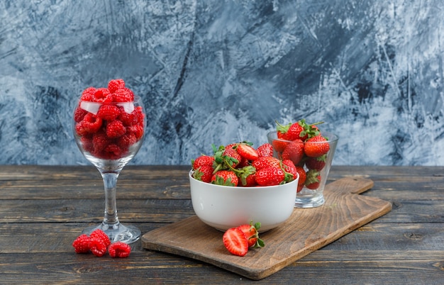 Aardbeien en frambozen in glazen containers