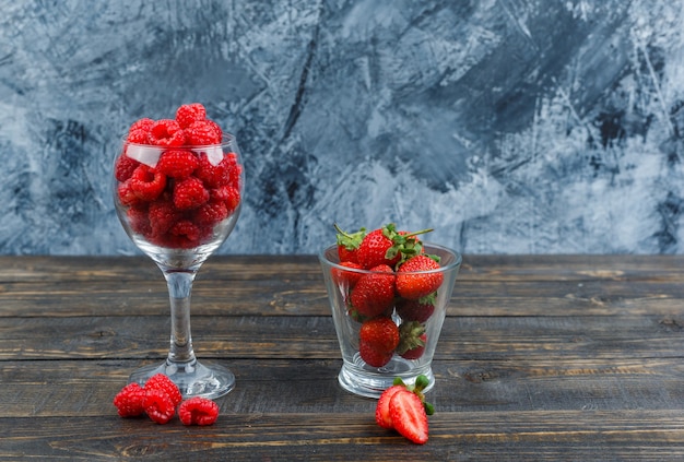 Aardbeien en frambozen in glazen containers