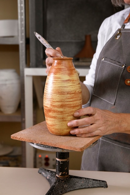 Gratis foto aardewerkvakman in de studio die keramiek maakt