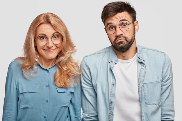 aarzelend twijfelachtige vrouw en man collega's, weet niet wanneer ze aan het werk moeten gaan, naast elkaar staan, geen idee hebben