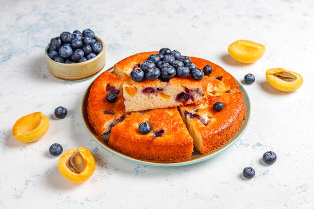 Abrikozen- en bosbessencake met verse bosbessen en abrikozenvruchten.