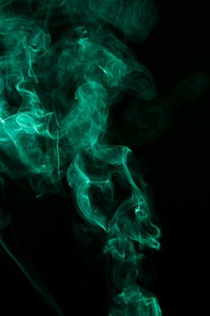 Abstracte groene piekerige rook die tegen zwarte achtergrond wordt uitgespreid