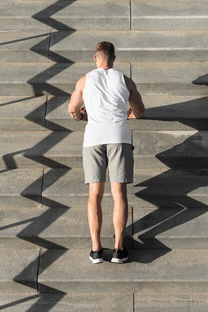 Achteraanzicht atletische man doet push-ups op trappen