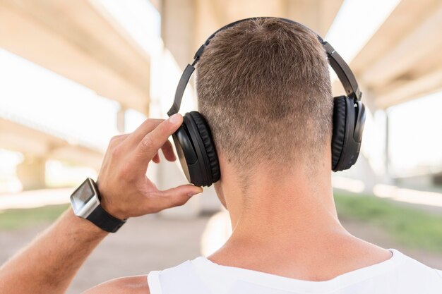 Achteraanzicht man luisteren naar muziek via de koptelefoon