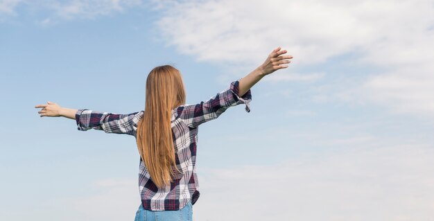 Achteraanzicht meisje geniet van de blauwe lucht