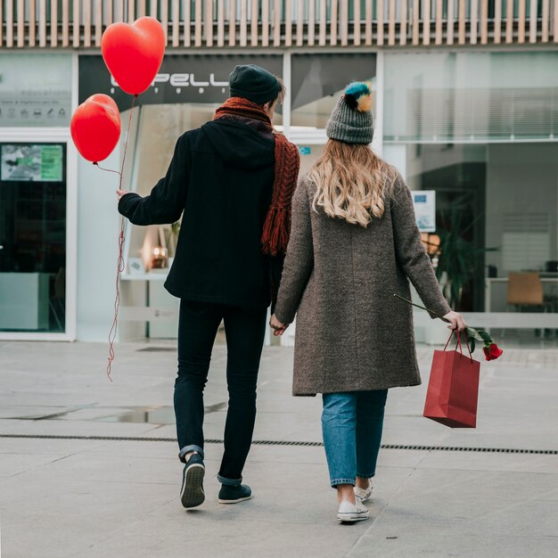 Achteraanzicht paar hand in hand en wandelen