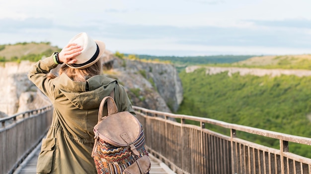 Gratis foto achteraanzicht reiziger lopen de brug af