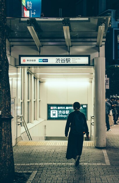 Achteraanzicht van de mens op weg naar metrostation