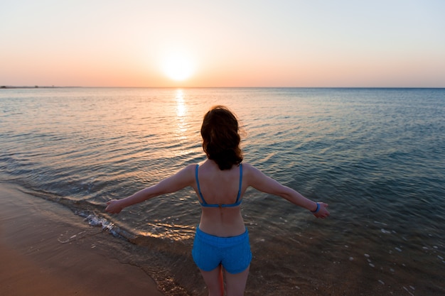 Achteraanzicht van de vrouw genieten van de zonsondergang