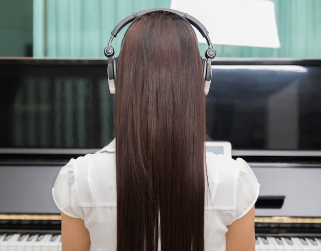 Achteraanzicht van de vrouw het spelen piano