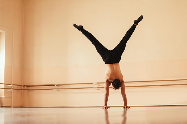 Gratis foto achteraanzicht van een danser die in een studio traint en een handstand doet ruimte kopiëren