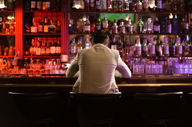 Achteraanzicht van een jonge man bier drinken