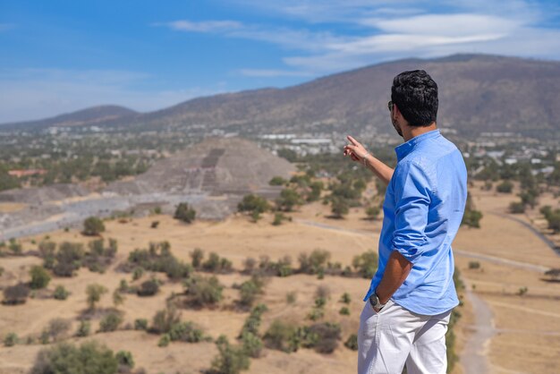 Achteraanzicht van een man met een blauw shirt op de achtergrond van San Juan Teotihuacan