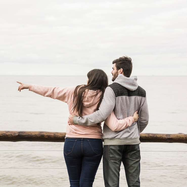 Gratis Foto achteraanzicht van liefdevolle jong koppel met uitzicht op zee