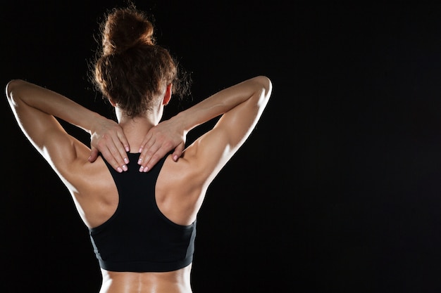 Gratis foto achteraanzicht van sterke fitness vrouw poseren in studio