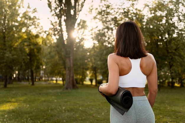 Gratis foto achteraanzicht vrouw met yoga mat