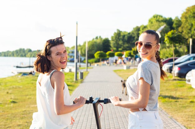 Achteraanzicht vrouwen op scooter kijken naar de camera