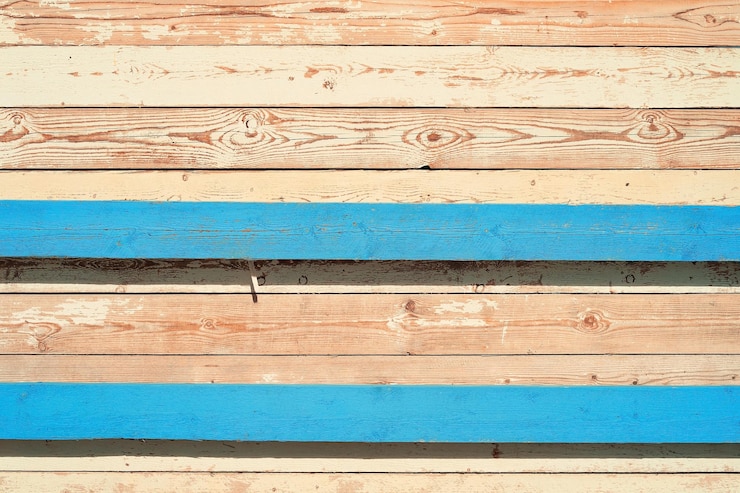Gratis Foto achtergrond van oude planken met heldere patronen de muur van de oude schuur in de felle zon verweerde en zongebleekte houten planken met overblijfselen van oude blauwe en witte verf