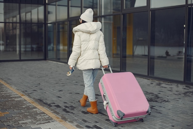 Achterkant foto van vrouw met bagage die naar de luchthaventerminal gaat