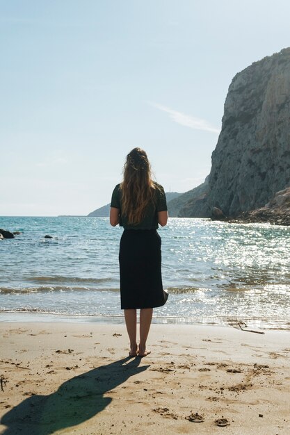 Achtermening die van jonge vrouw zich op mooi strand bevinden