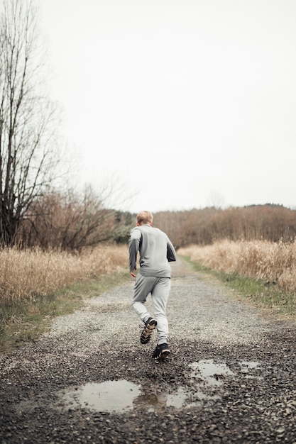 Achtermening van de mens die op de weg in het midden van het gebied lopen