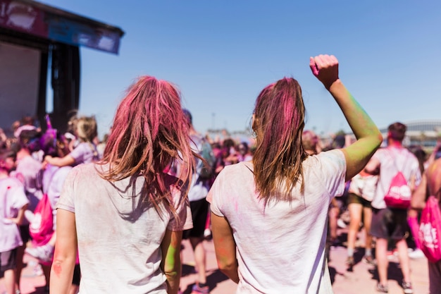 Gratis foto achtermening van een jonge vrouw twee die in holifestival dansen