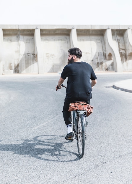 Achtermening van een mens die de fiets berijden op weg