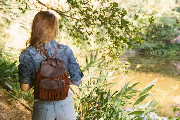 Achtermening van een vrouw die zich in bos bevindt