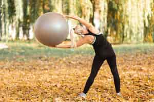 Gratis foto achtermenings mooie vrouw die een gymnastiekbal gebruiken