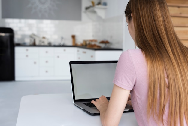 Achtermeningsvrouw die haar laptop model controleren