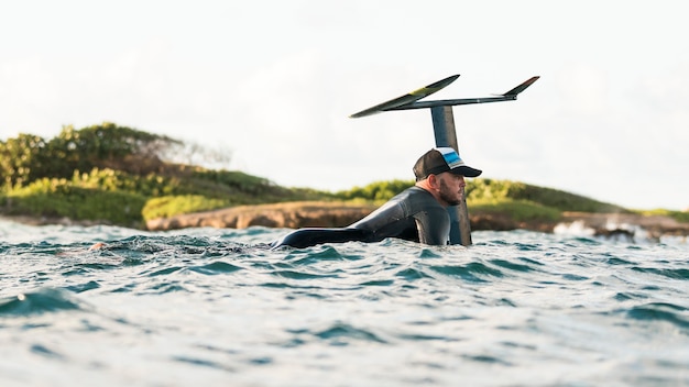 Actieve man in speciale uitrusting die op een surfplank verblijft