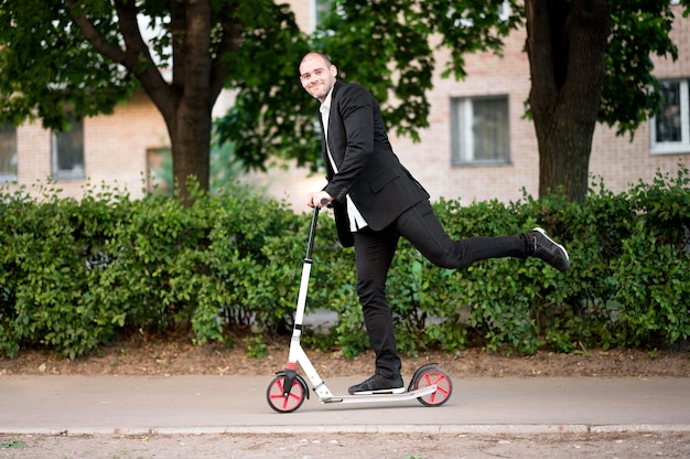 Actieve zakenman rijden scooter buitenshuis