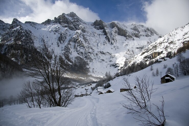 Gratis Foto adembenemend landschap van de met sneeuw bedekte bergen onder een schilderachtige bewolkte hemel