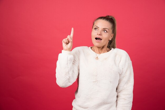 Afbeelding van een gelukkige vrouw die een vinger omhoog wijst