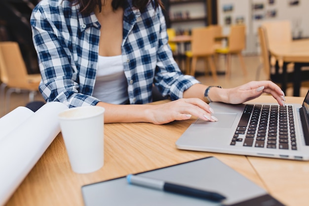 Afbeelding van een jonge vrouw die met laptop werkt aan tafel omringen creatieve dingen. Freelancer, slimme student, moderne tijd, werken op internet, zoeken, surfen.