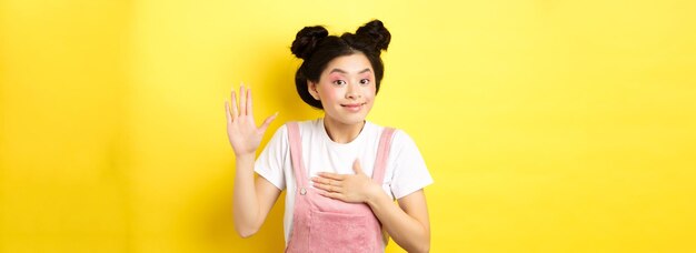 Afbeelding van een schattig aziatisch meisje met make-up die eerlijk is en de hand opsteekt en op het hart zet en de waarheid vertelt