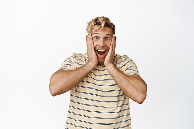 Afbeelding van een supergelukkige volwassen man die op positief nieuws reageert en lacht en lacht en kijkt met enthousiast ongeloof op een witte achtergrond