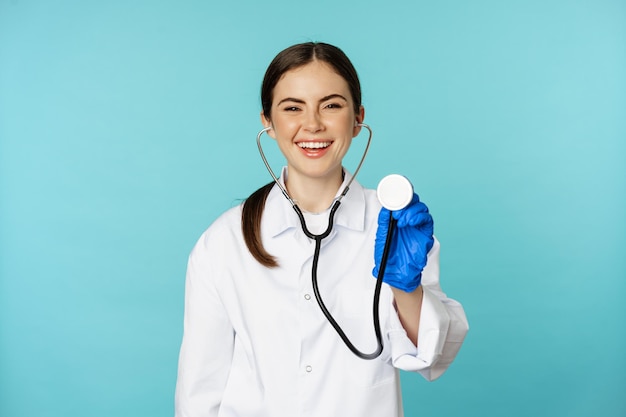 Afbeelding van vrouwelijke arts die de longen van de patiënt luistert met een stethoscoop die medische controle doet in de kliniek...